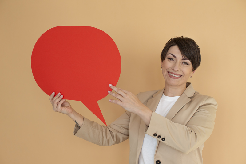 Inglés Básico Conversacional. Una persona señalando un globo de conversación de color rojo.